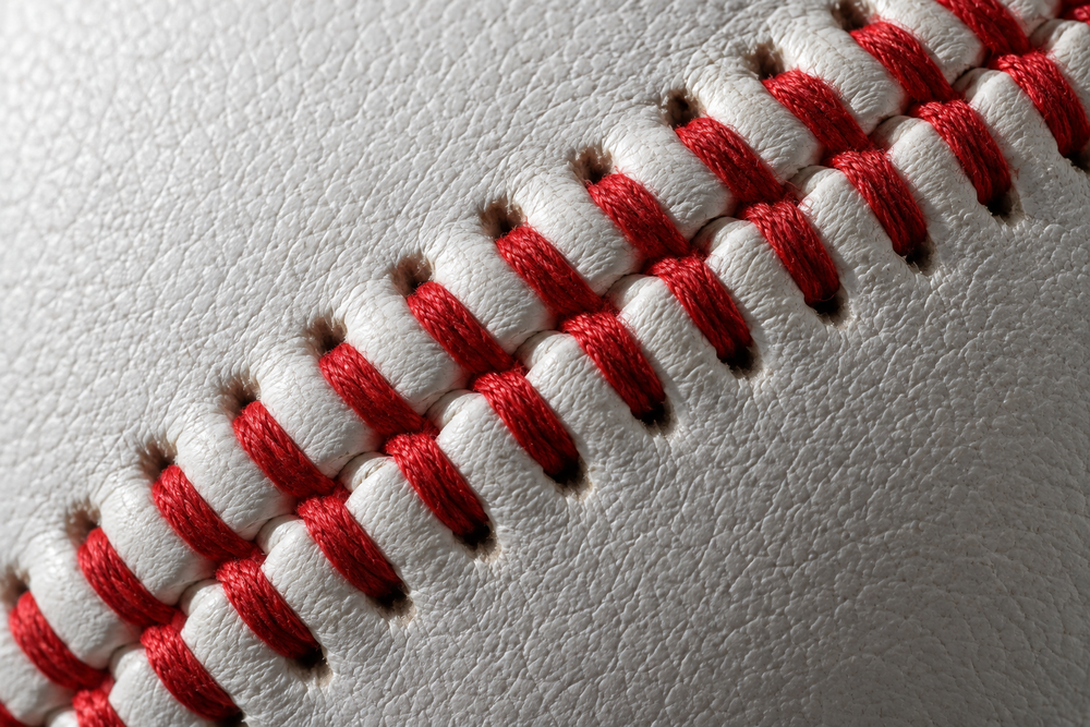 Close-up of red raised stitching on a full-grain leather baseball
